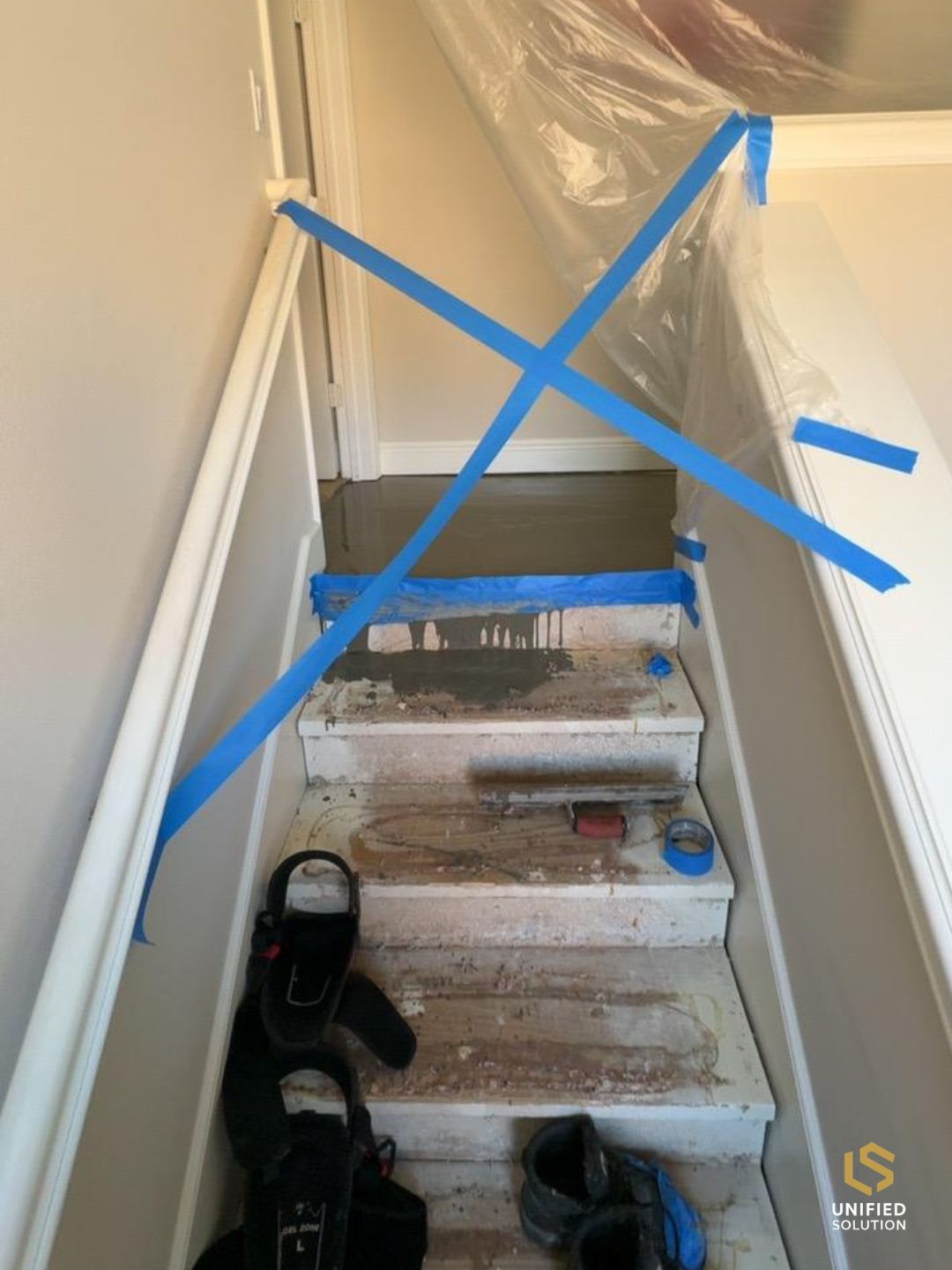 Staircase protected with plastic sheeting and tape during a flooring job