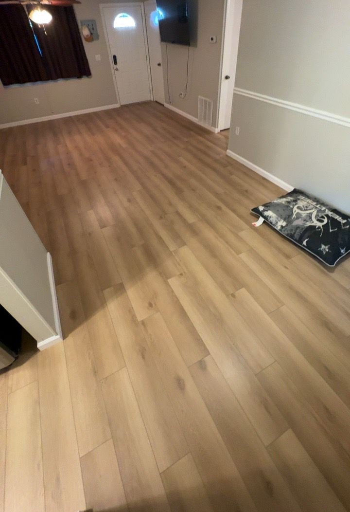 Same living room finished with warm oak-tone luxury vinyl plank